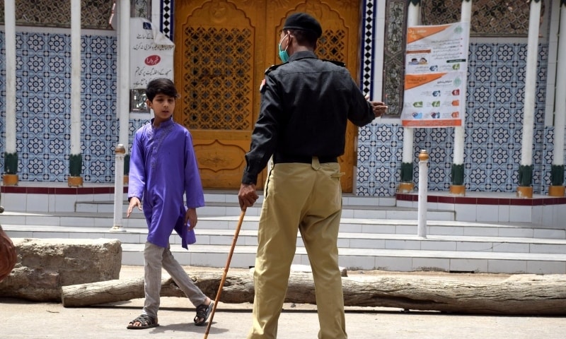 A police official reprimands a young child for violating the lockdown in Hyderabad. &mdash; Photo Umair Ali