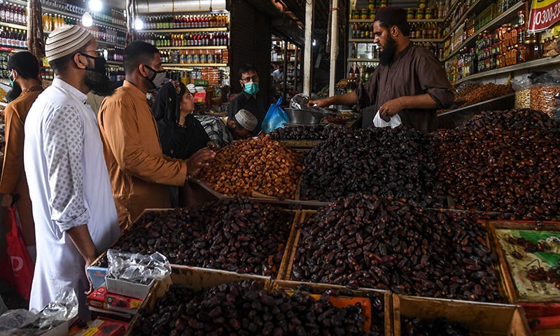 People buy dates at a market ahead of Ramazan in Karachi on April 24. &mdash; AFP
