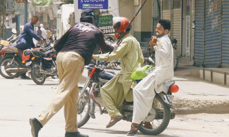 A policeman uses force to intercept violators of ban on pillion riding Hyderabad. — Online