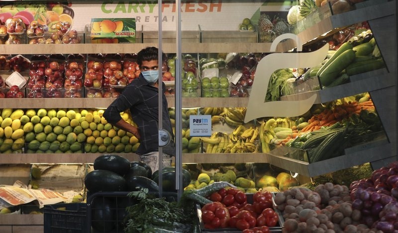 An Indian fruit vendor wearing a face mask as a precaution against the new coronavirus waits for customers during lockdown in Bangalore, India, Friday, April 24. — AP