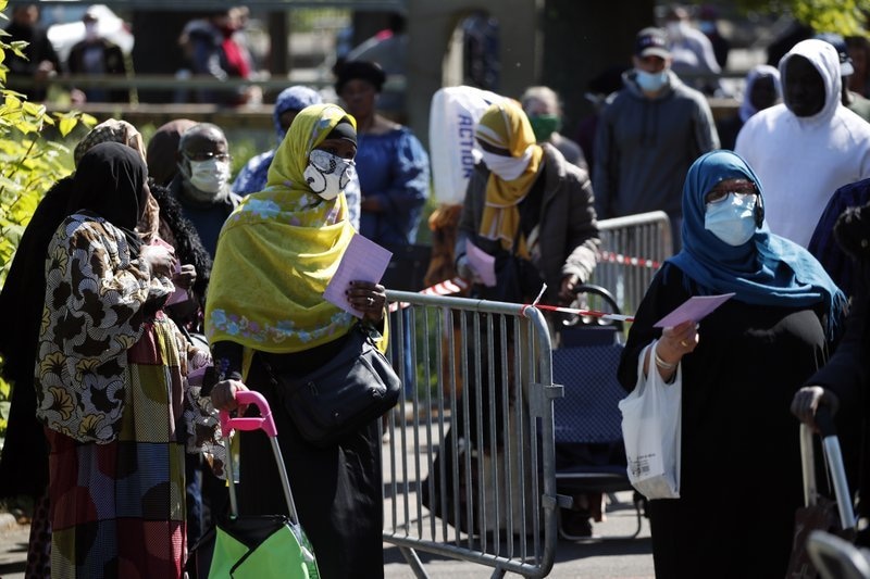 In this April 22 file photo, residents arrive to collect soap, vegetables, fruits and other staples distributed by volunteers from community organisations in Clichy-sous-Bois, a suburb north of Paris. — AP
