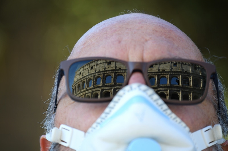 The Colosseum is seen reflected in the glasses of a man wearing a face mask, as the spread of the coronavirus continues, in Rome, Italy, April 26, 2020. — Reuters