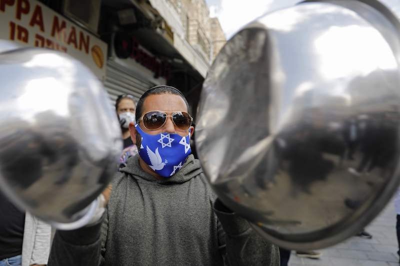 A merchant in Jerusalem's Mahane Yehuda market, bangs pots as he protests the continued closure of the landmark open air market, after authorities reduced some lockdown measures imposed in order to stem the spread of the novel coronavirus, by allowing shops to reopen, on April 26, 2020. — AFP
