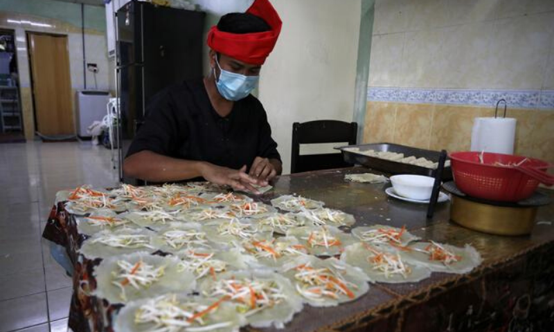 An online Ramazan bazaar trader wraps "Popiah" spring rolls at his home, during the movement control order due to the coronavirus outbreak, in Sungai Buloh, Malaysia. — Reuters