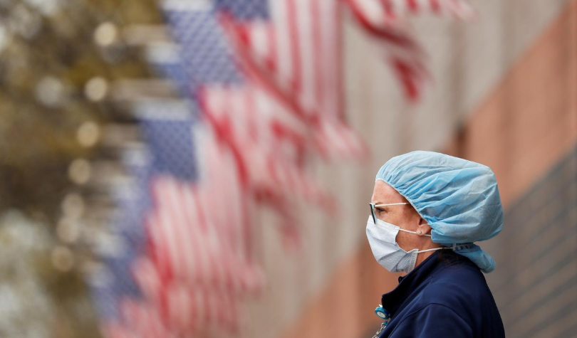 A nurse wearing personal protective equipment watches an ambulance driving away outside of Elmhurst Hospital during the ongoing outbreak of Covic-19 in the Queens borough of New York, US. — Reuters