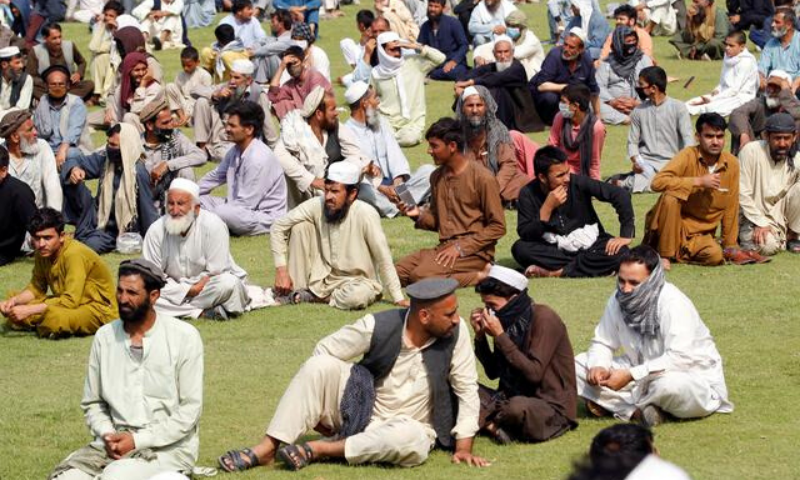 Men wait to receive free food donated by the Afghan government, amid the spread of the coronavirus, in Jalalabad, Afghanistan on Tuesday. — Reuters