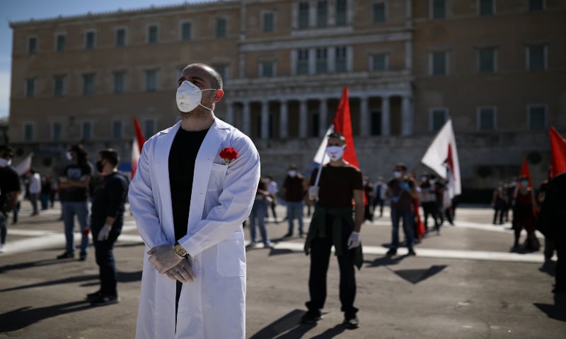 Members of the communist-affiliated trade union PAME wear protective masks as they practice social distancing during a rally commemorating May Day, following the coronavirus disease in Athens, Greece. &mdash; Reuters