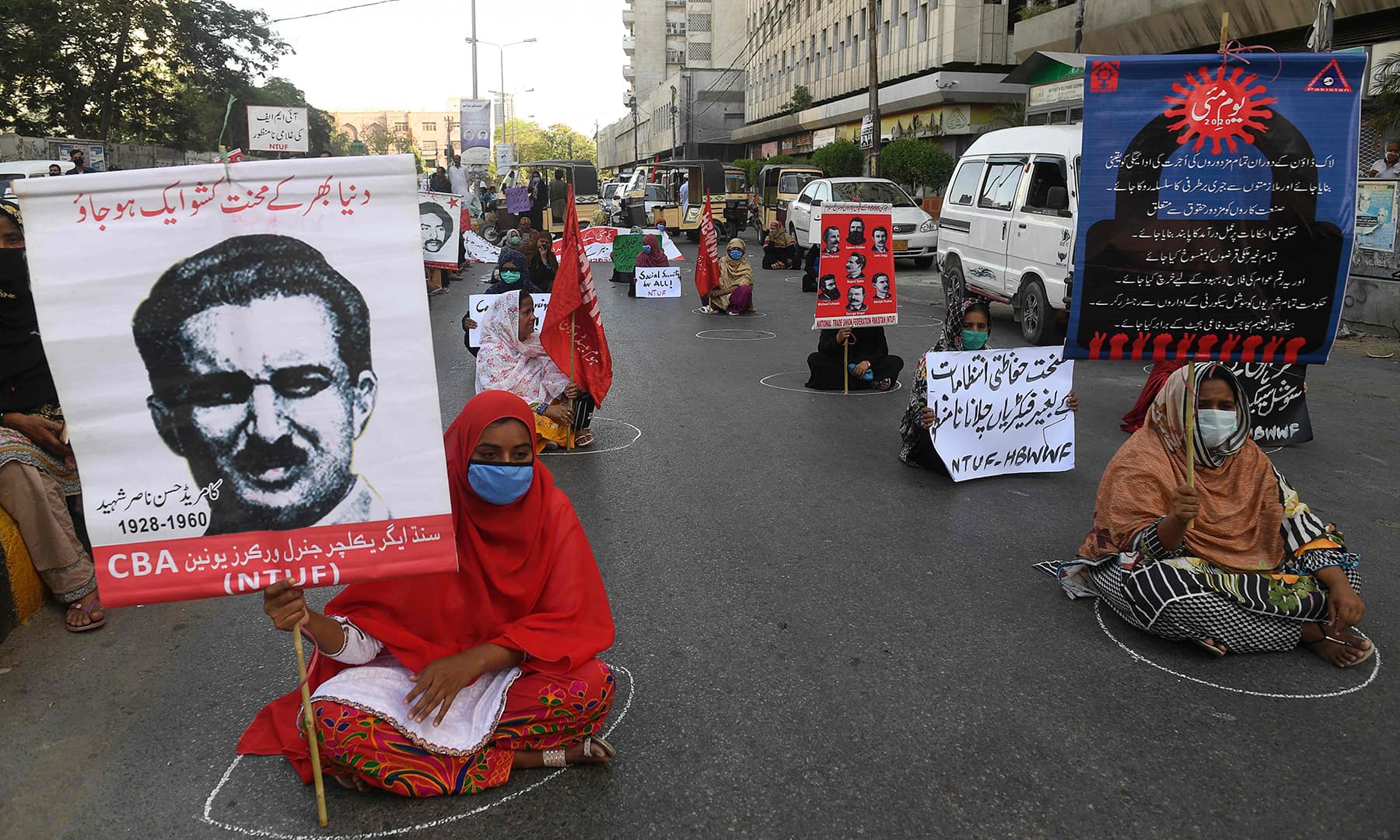 Labour union workers maintain social distancing as they carry placards during a May Day rally in Karachi on May 1. — AFP