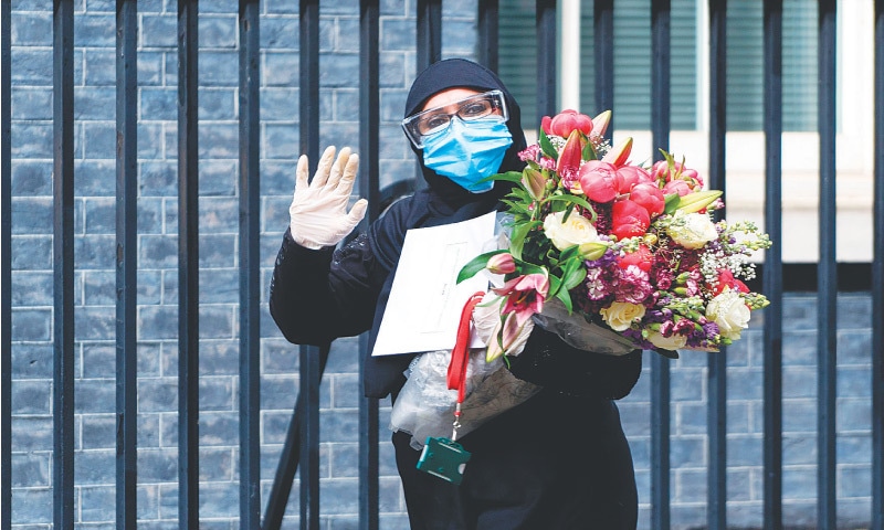 In this April 30 photo, Naghma Butt arrives to deliver a bouquet of flowers 
to 10 Downing Street, the official residence of Britain’s prime minister, 
in central London.—AFP