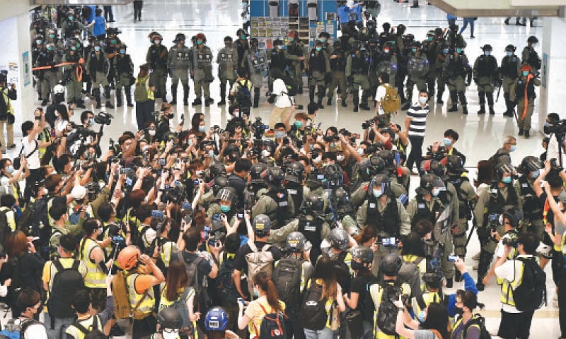Hong Kong: Riot police carry out a crowd dispersal operation on Friday as members of the media take photos during a protest in a shopping mall by pro-democracy supporters.&mdash;AFP