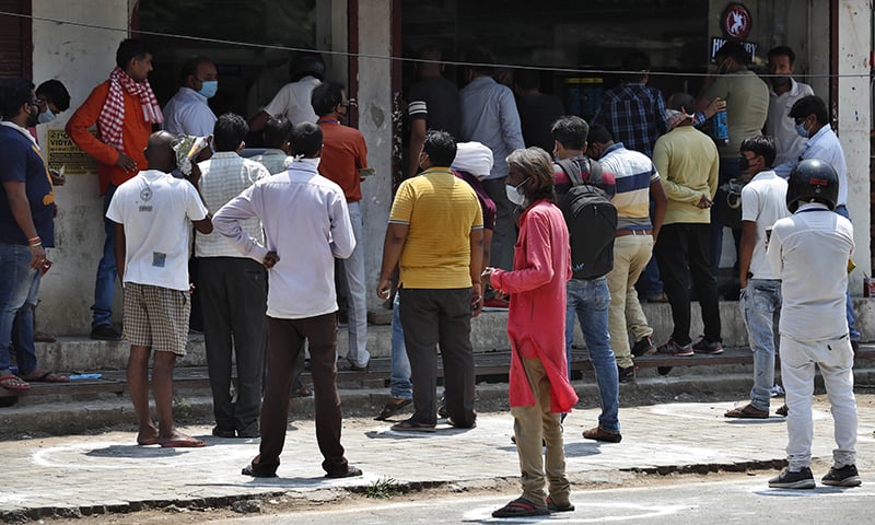 Indians wait to buy liquor outside one of the shops which were reopened Monday after six weeks lockdown in Prayagraj, India, Monday. — AP