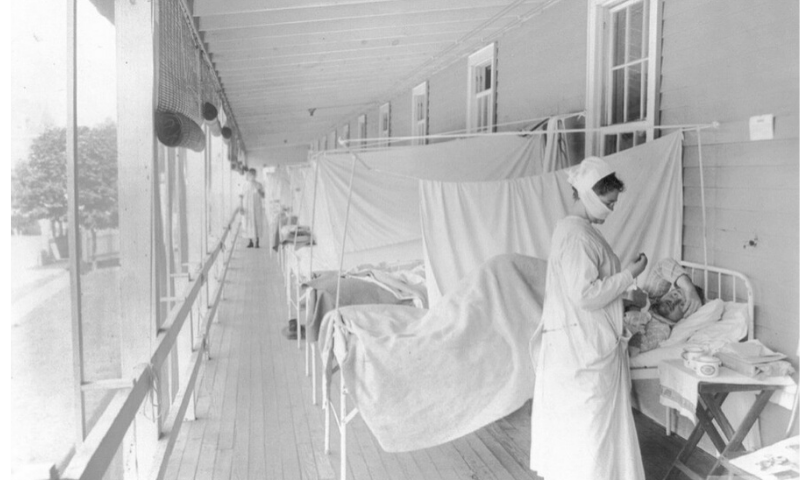 In this November 1918 photo made available by the Library of Congress, a nurse takes the pulse of a patient in the influenza ward of the Walter Reed hospital in Washington. — AP