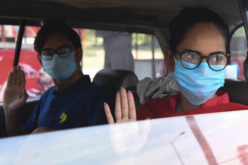 Pakistani nationals, who were stranded in India following the closure of borders due to the Covid-19 lockdown, wave before returning to their country via the India-Pakistan Wagah border post. — AFP