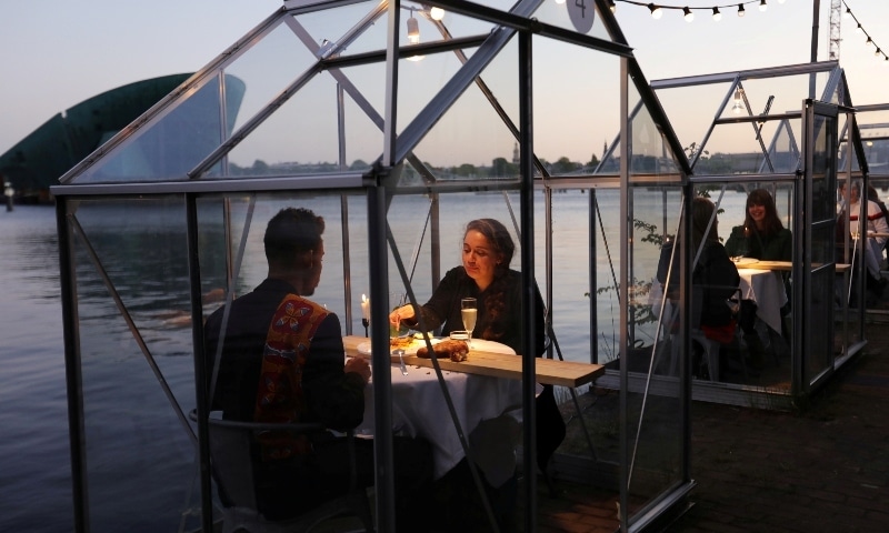 Servers provide drinks and food to models pretending to be clients in safe “quarantine greenhouses” in Amsterdam on May 5. — Reuters