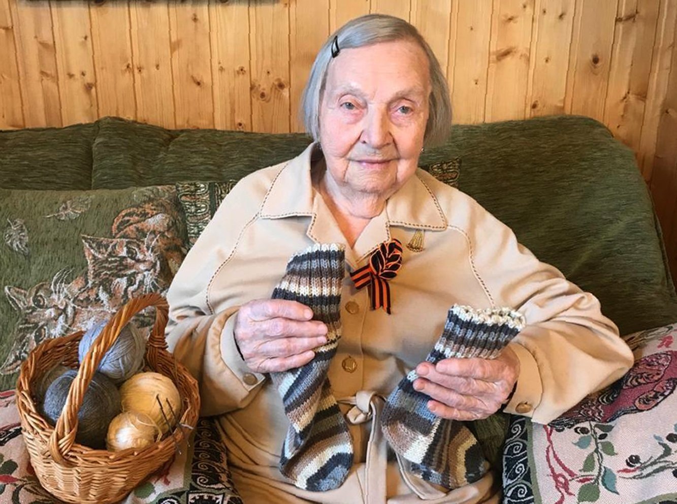 In this family photo taken by Dmitry Panov, Zinaida Korneva, World War II veteran, shows the socks she knitted for Tom Moore, a British World War II veteran who raised millions of pounds for charity in the run-up to his 100th birthday, during her interview with the *Associated Press* in St Petersburg, Russia, May 5. — AP