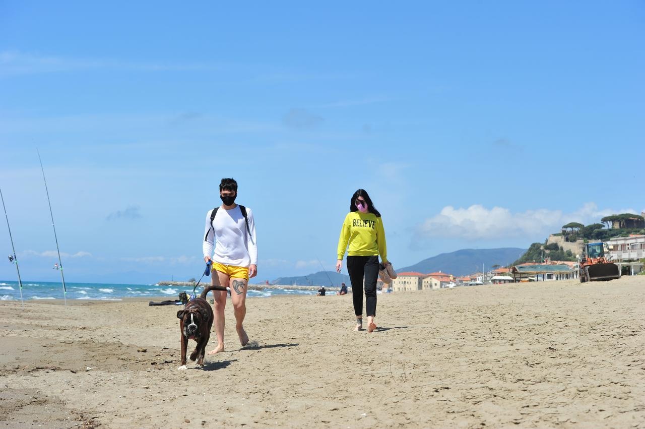 People walk along the beach as Italy begins to ease some of the restrictions of Covid-19 lockdown in Castiglione della Pescaia, Italy, May 9. — Reuters