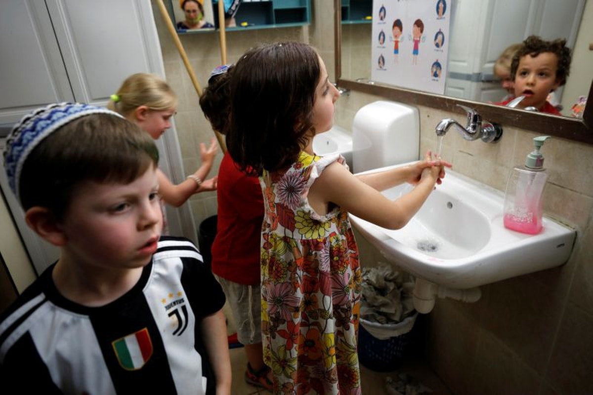 Children wash their hands at a kindergarten as Israeli preschools opened under the further easing of restrictions to prevent the spread of Covid-19 in Jerusalem, May 10. &mdash; Reuters