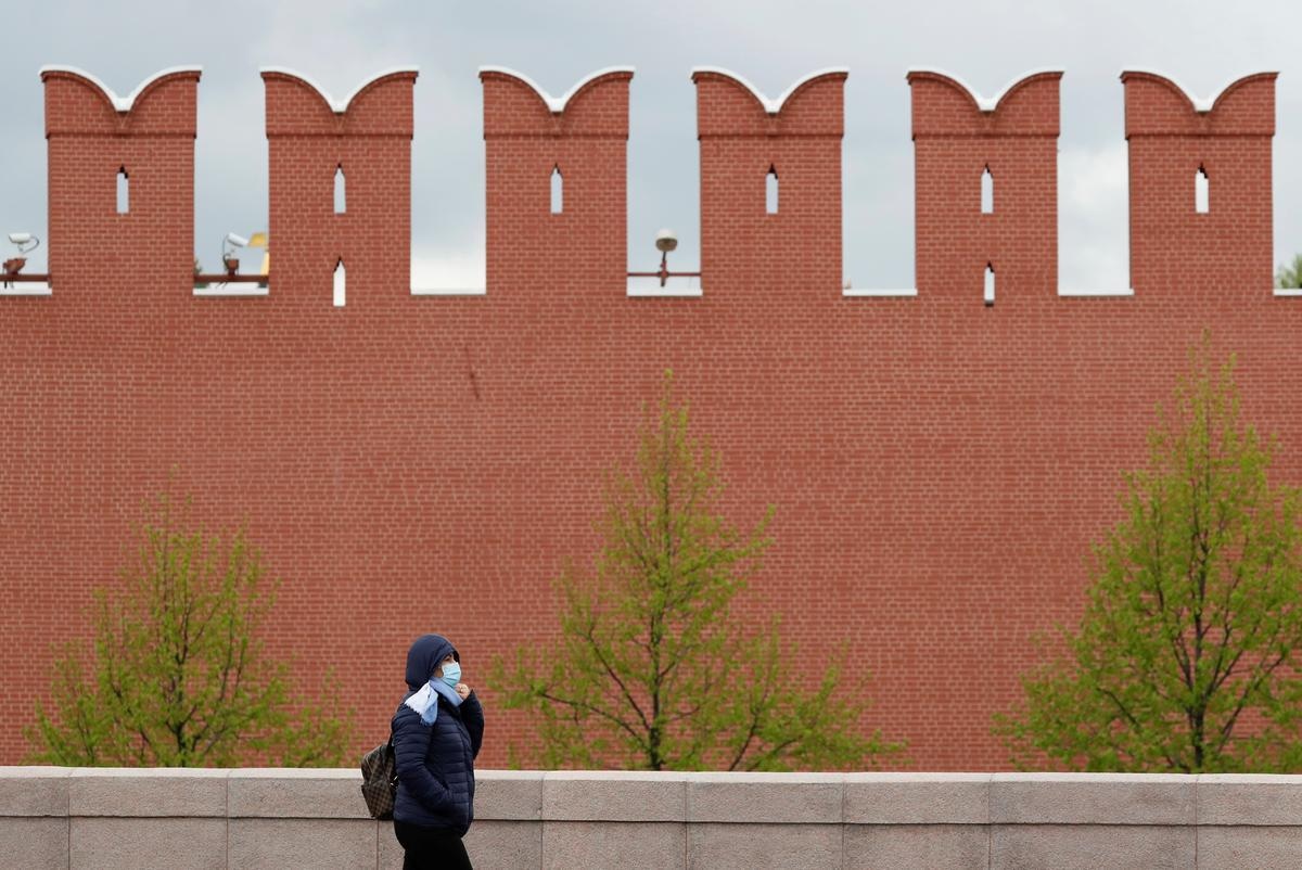 A woman wearing a protective face mask walks past the Kremlin wall amid the outbreak of Covid-19 in Moscow, Russia, May 8. &mdash; Reuters
