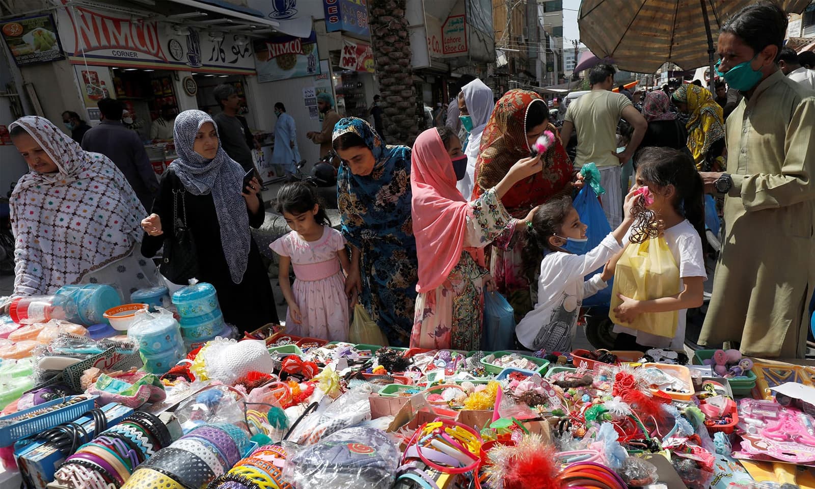 وائرس کے خطرے کے باوجود والدین نے بچوں کے ہمراہ بازاروں کا رخ کیا — فوٹو: رائٹرز