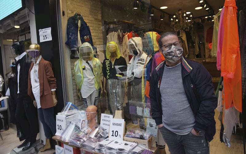 A man wearing a face mask for protection against the coronavirus waits for customers at the entrance of his shop in Ankara, Turkey, on Monday, May 11, 2020. Shopping malls, barber shops, hairdressers and beauty salons have reopened for business across Turkey for the first time in seven weeks as the country gradually eases restrictions aimed to prevent the spread of the new coronavirus. — AP