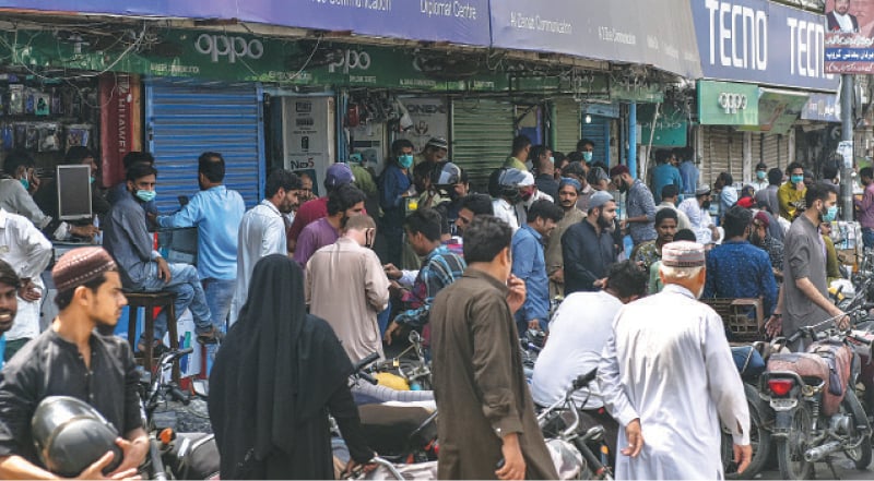 People gather at Saddar’s mobile market to meet their needs related to cell phones on Monday.—Fahim Siddiqi / White Star