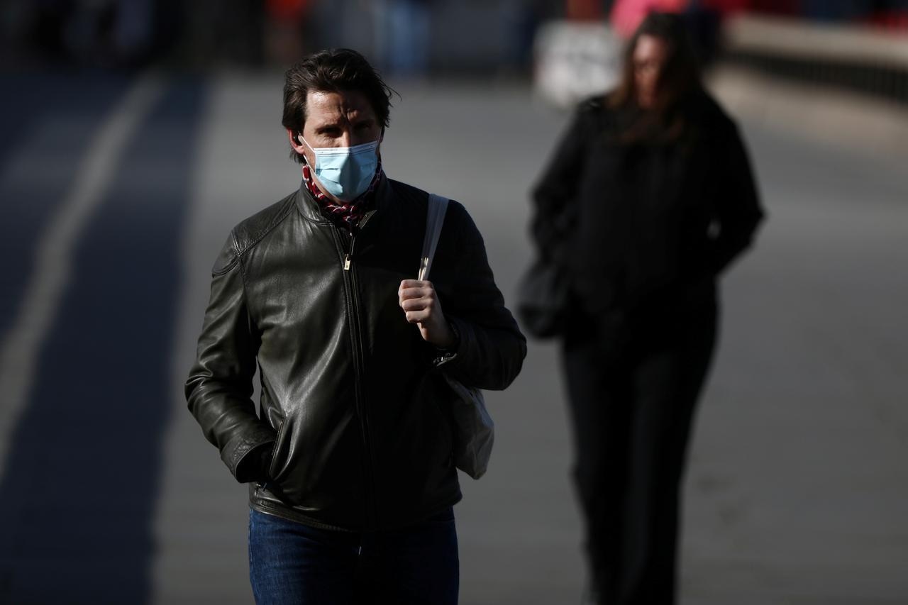 A man wearing a protective face mask walks along London Bridge following the outbreak of Covid-19, London, Britain, May 11. — Reuters
