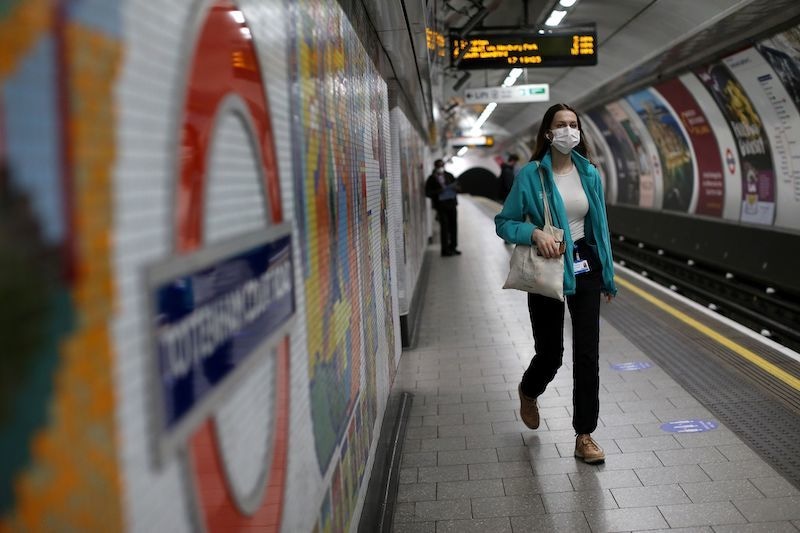 TOPSHOT - Commuters, some wearing PPE (personal protective equipment) including face masks as a precautionary measure against COVID-19,  travel by public transport during the evening 'rush hour', on TfL (Transport for London) underground trains, in central London on May 14, 2020. - Britain has had more than 36,000 deaths in the outbreak -- the second-worst in the world -- but has partially lifted lockdown measures in England this week. The government has been accused of putting workers' lives at risk by easing restrictions while the daily death toll is still hovering around 500. (Photo by Isab