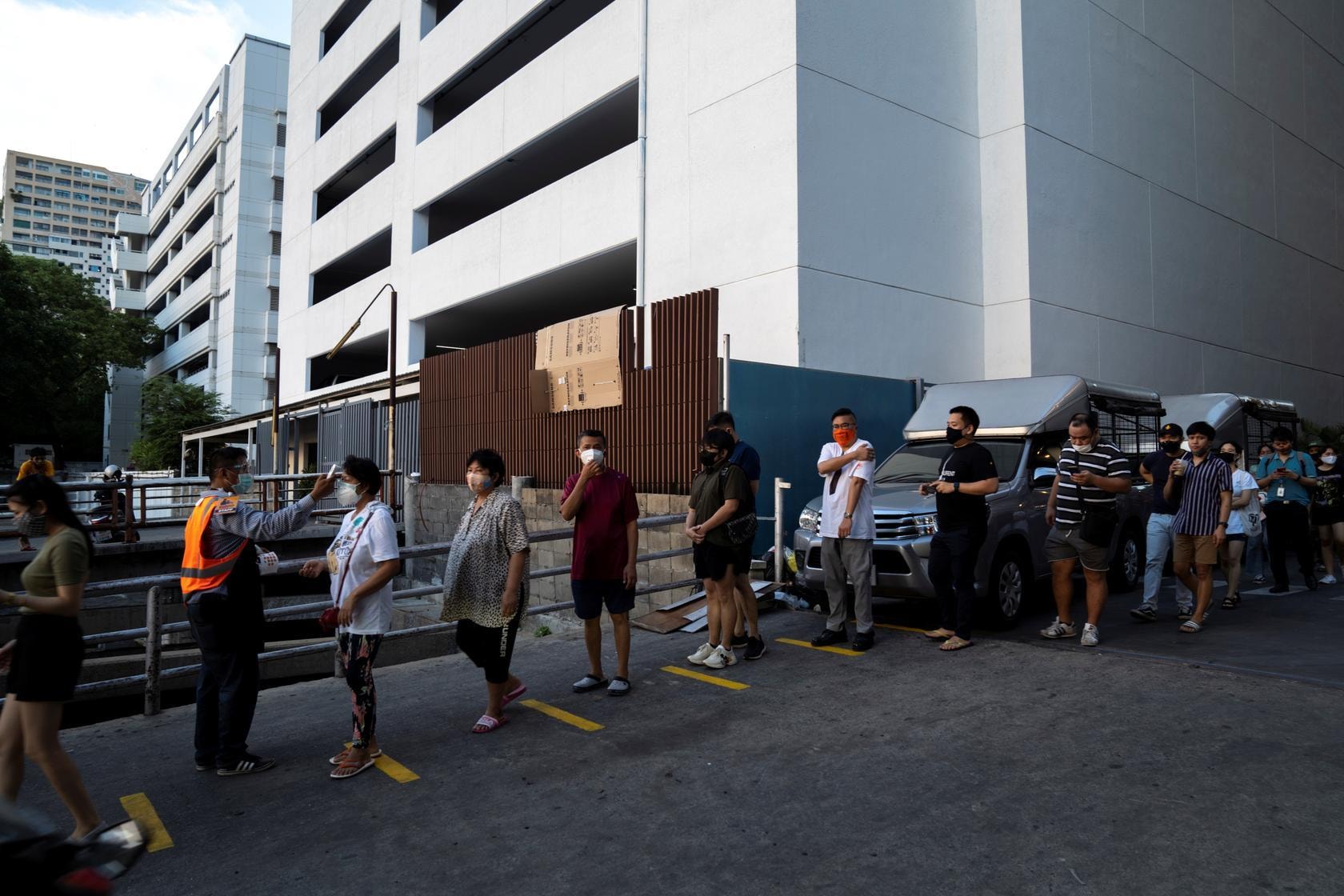 People queue up to have their temperatures taken before entering the Ratchada Railway Night Market, which is reopening amid Covid-19 outbreak, after the Thai government eased isolation measures, in Bangkok, Thailand, May 15. &mdash; Reuters