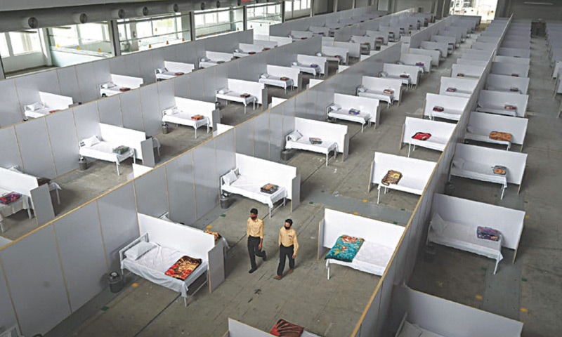 Private security guards walk inside a temporary islocation facility set up at the Expo Centre in Jauhar Town, Lahore to treat Covid-19 patients in case exisiting health facilities in Lahore and Punjab run short. The field hospital can accommodate up to 1,000 patients. The number of confirmed Covid-19 cases in Punjab rose to 11,568 on May 11 | AFP