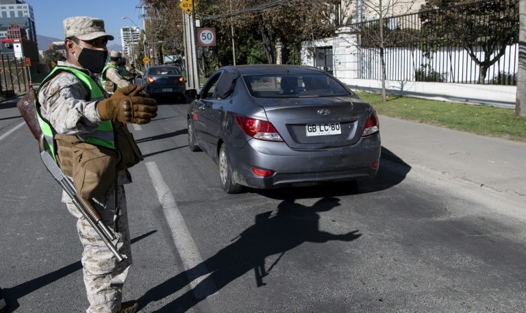 Soldiers stop cars at a checkpoint in Santiago, amid mandatory total quarantine due to the novel coronavirus pandemic. &mdash; AFP