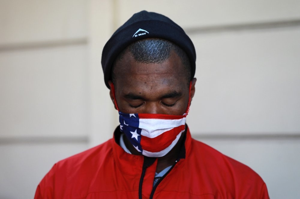 In this May 2 photo, Preston, a senior leader of the Americans, a criminal gang, says a prayer before he and other gang members deliver food in the Manenberg neighbourhood of Cape Town, South Africa. &mdash; AP