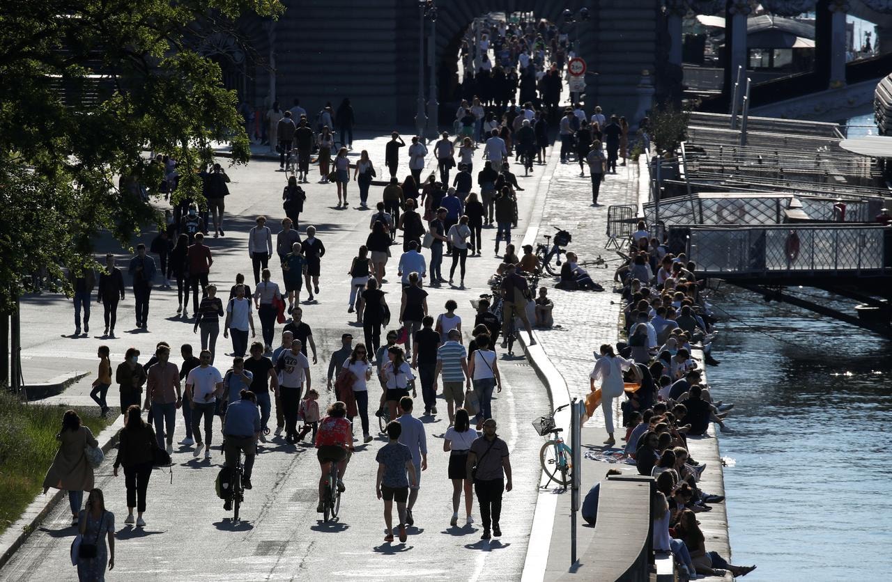 People walk on the banks of the river Seine after France began a gradual end to a nationwide lockdown, in Paris, France, May 17. &mdash; Reuters