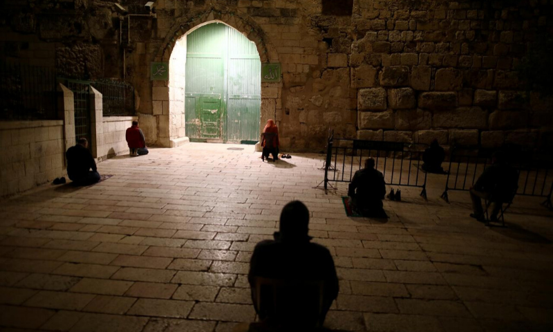 Worshippers pray near the closed gate of the compound housing Al-Aqsa mosque for Ramazan prayers, as mosques were closed due to the coronavirus. — Reuters/File
