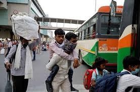 A worker carries on the shoulders his physically challenged brother to a bus that will take them to their home state of Uttar Pradesh. &mdash; Reuters