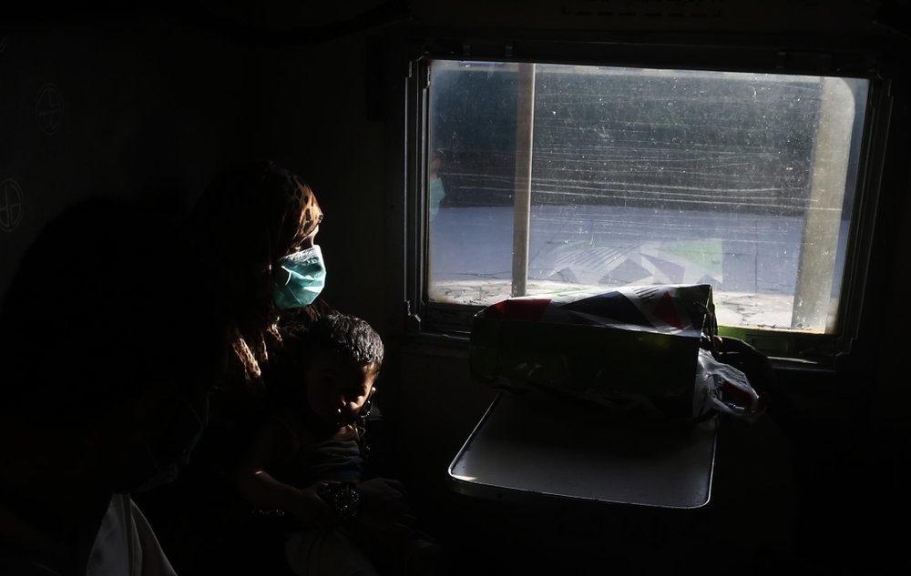 A mother wearing a face mask travels with her son on a train in Lahore, May 20. The government resumed railway service after a two month suspension. &mdash; AP