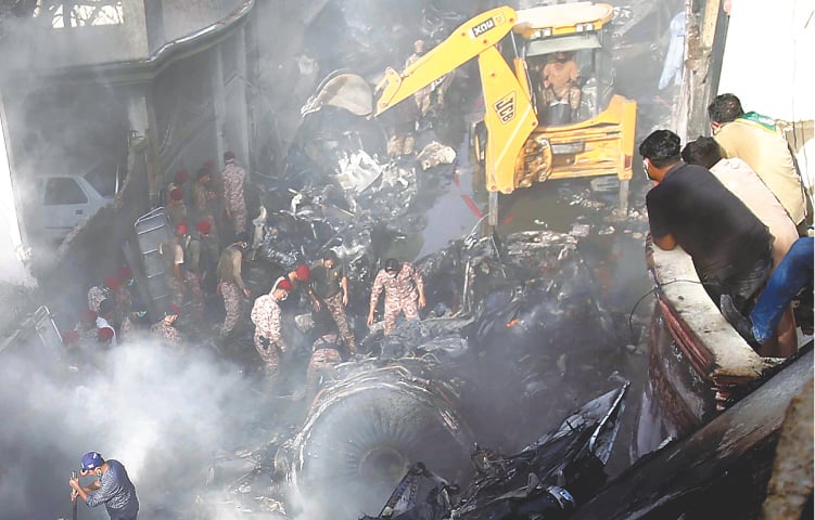 HEAVY machinery removes debris at the site of the tragedy on Friday.—Shakil Adil/White Star