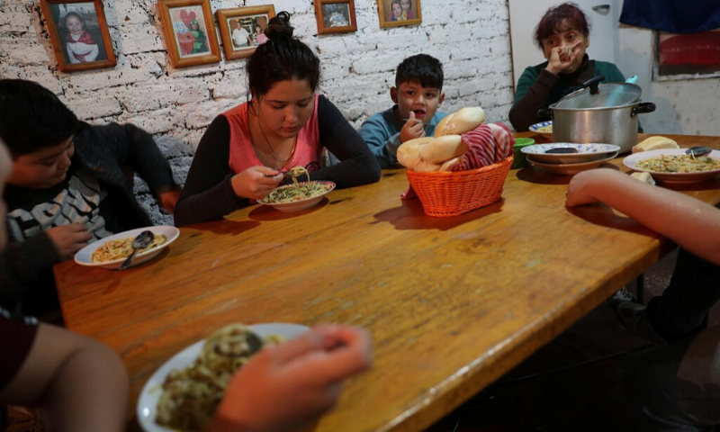 A family share food rations deliver from a so called "Olla comun", a communal cook-up to provide plates of hot food to those with dwindling incomes or nothing at all at Villa Francia area. — Reuters