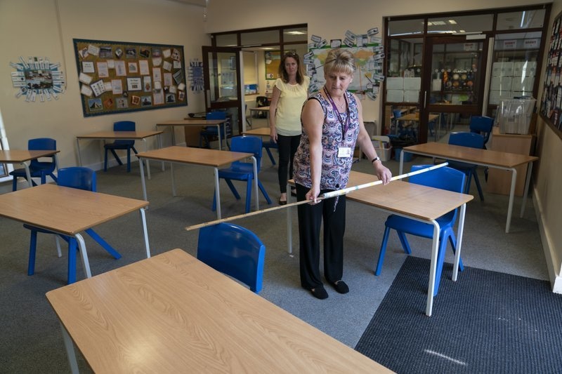 Year 6 teacher Jane Cooper uses a 2 metre length of ruler and pipe to check seat spacings in her classroom as measures are taken to prevent the transmission of coronavirus before the possible reopening of Lostock Hall Primary school in Poynton near Manchester, England, May 20. — AP
