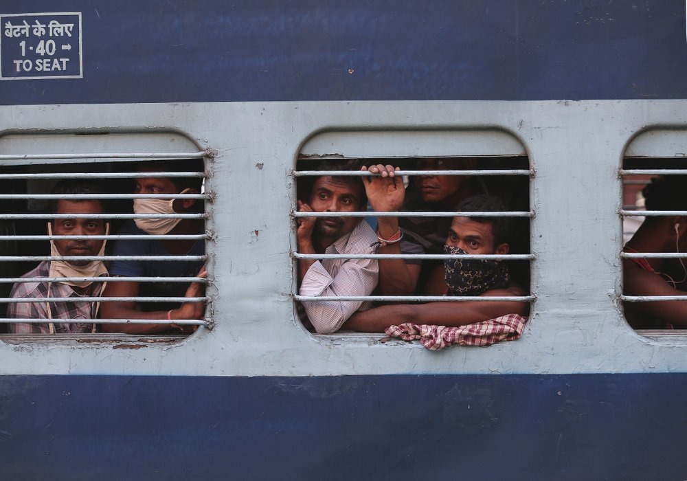 Migrant workers look out a train window before moving to their home states, at Hyderabad Railway Station in Hyderabad, India, May 23. — AP