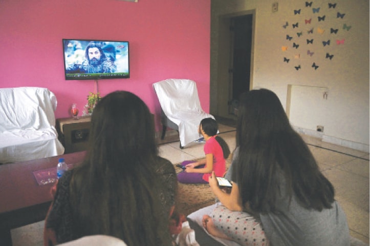 ISLAMABAD: A family watches a Turkish drama series telecast on state-run channel PTV Home.—AFP