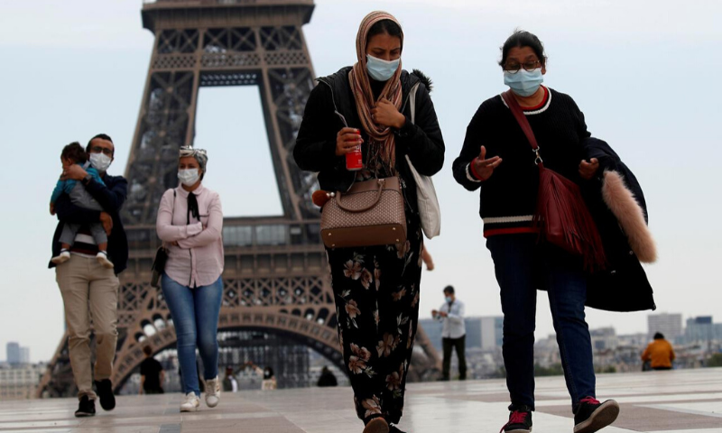 People wearing face masks walk at Trocadero square near the Eiffel Tower, as France began a gradual end to a nationwide lockdown due to the coronavirus. &mdash; Reuters/File