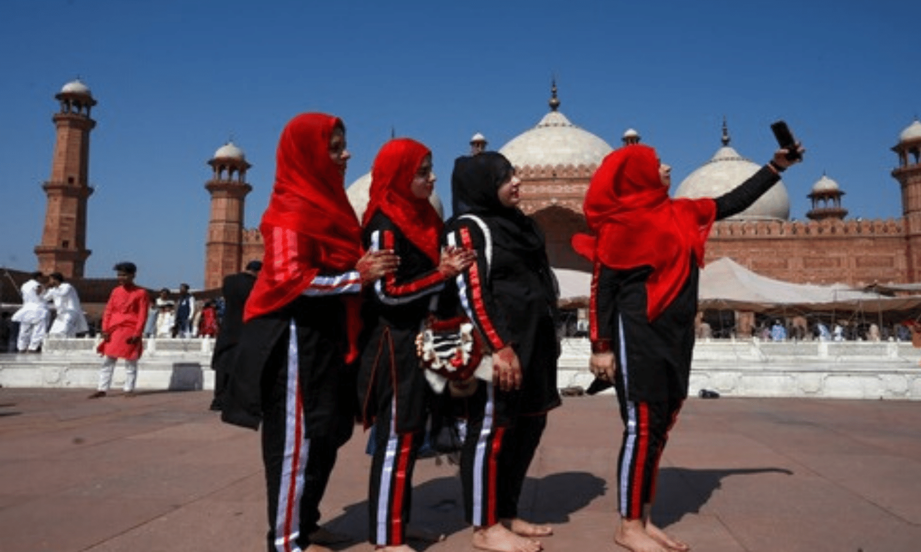 Women take selfies after offering Eidul Fitr prayers at the Badshahi Mosque in Lahore. — AFP