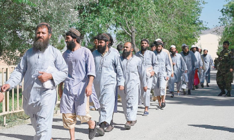 Taliban prisoners walk in line as they are released from the Bagram prison, situated about 50km from Kabul, on Tuesday.—AFP