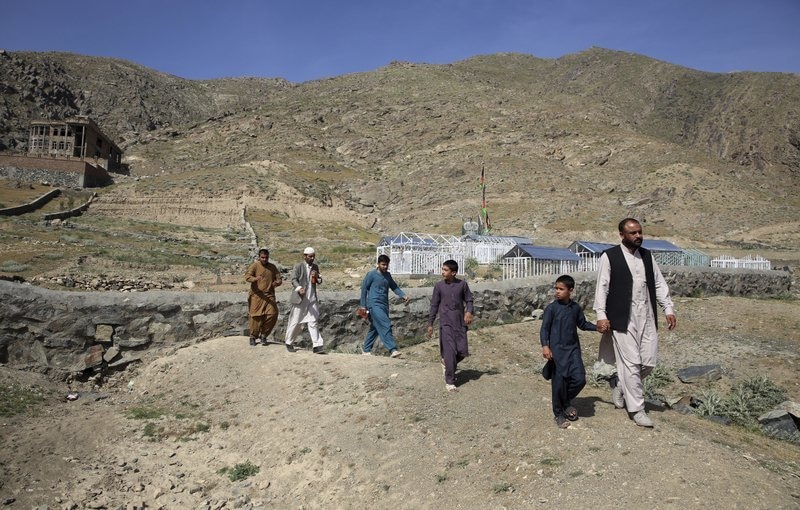 In this May 20 photo, members of the Aryubi family walk to a graveyard where Dr Yousuf Aryubi and two siblings who lost their lives to Covid-19 are buried, in Kabul, Afghanistan. — AP