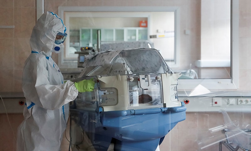 A medical specialist wearing PPE takes care of a newborn baby at the maternity ward of the City Clinical Hospital Number 15 in Moscow, Russia, May 25. — Reuters