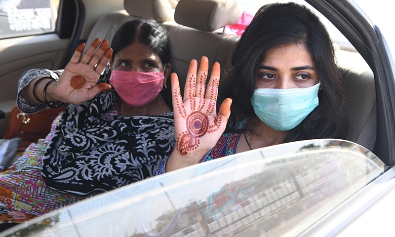 Pakistani nationals,&nbsp;who were stranded in India following the closure of borders due to the coronavirus&nbsp;lockdown,&nbsp;wave goodbye before crossing the Attari-Wagah border on May 27. &mdash; AFP