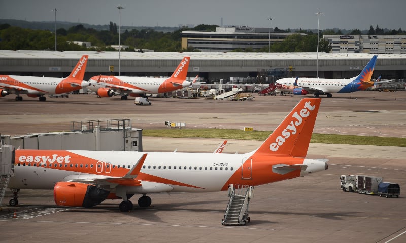 In this file photo taken on May 11, 2020, Easyjet aircraft stand on the apron the departure gates at Manchester Airport in Manchester, northern England where they have begun a trial of body temperature screening. &mdash; AFP