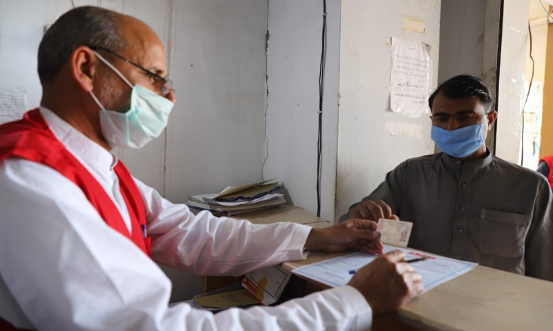A refugee receives cash assistance from UNHCR at a Post Office branch in Pakistan, May 2020. &mdash; Photo provided by Naveed Siddiqui via UNHCR