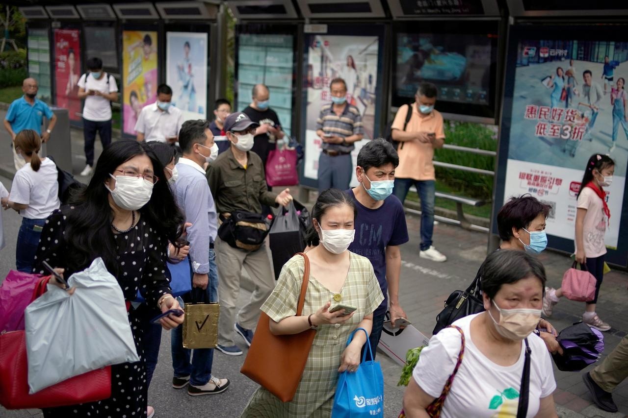 People wearing protective face masks are seen on a street following an outbreak of the novel coronavirus in Shanghai, China on May 28. — Reuters