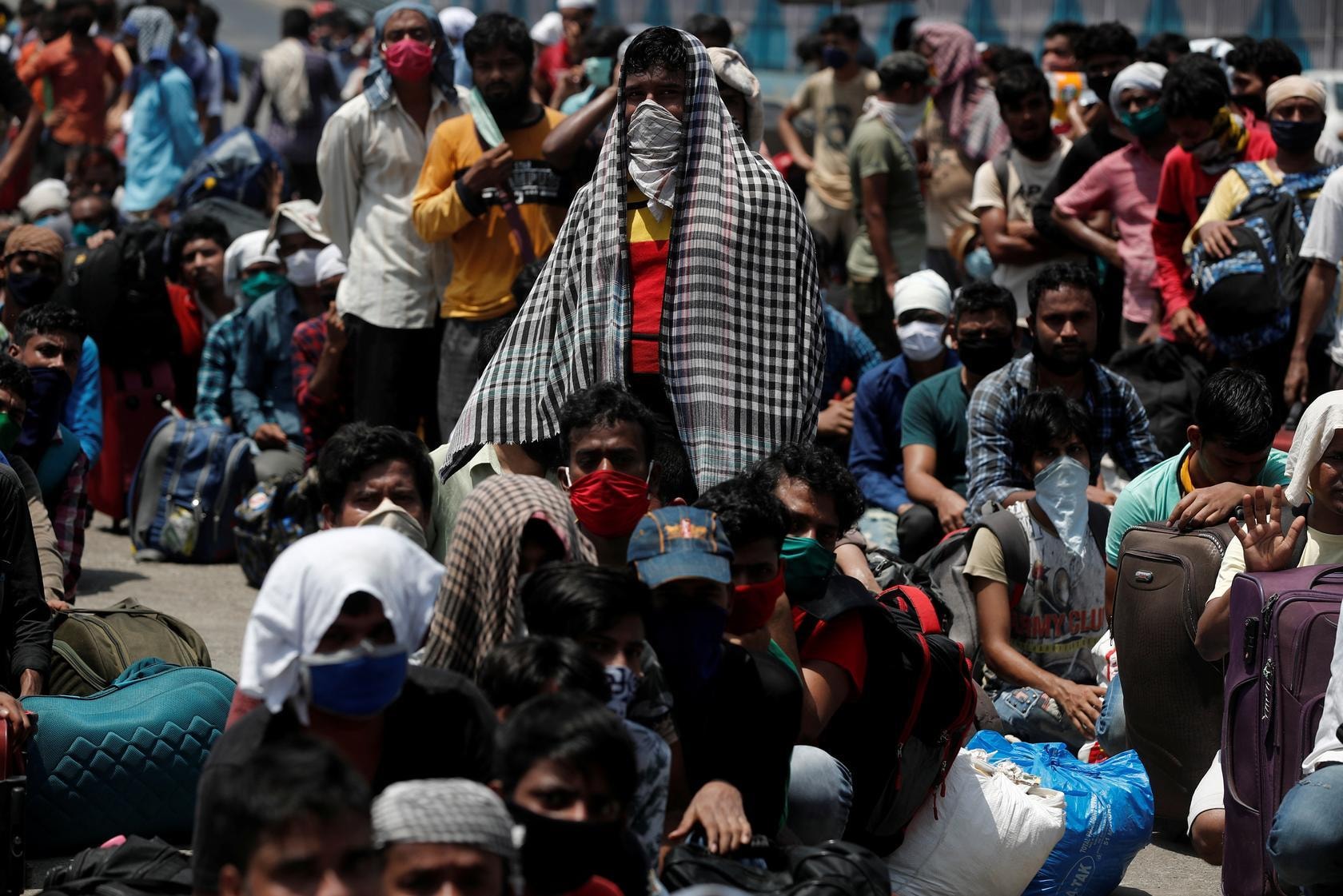 People wait in a line to board a train that will take them to their home state of Uttar Pradesh, during an extended lockdown to slow the spreading of the coronavirus disease, in Mumbai, India, May 26. — Reuters
